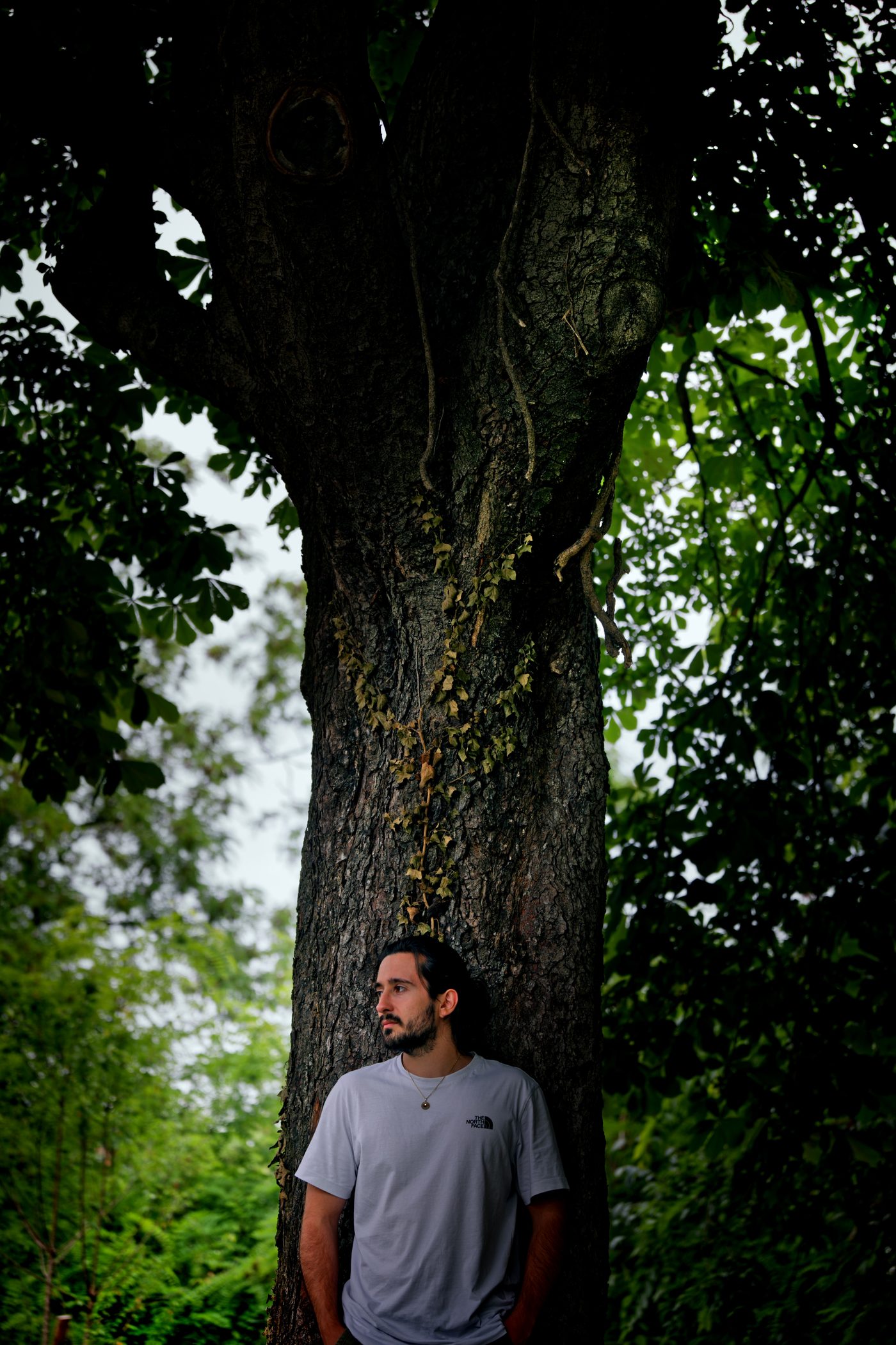 Portrait en extérieur à Lyon — Gabriel adossé au tronc d'un grand arbre