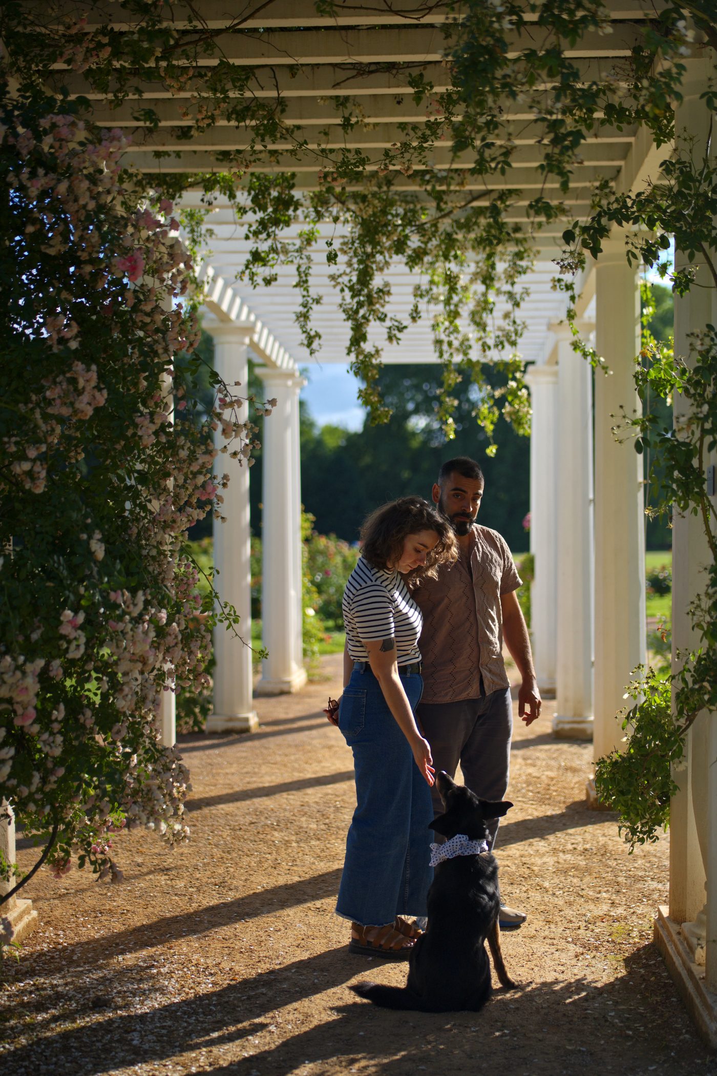 Portrait de couple à Lyon — un couple et leur chien sous une pergola fleurie